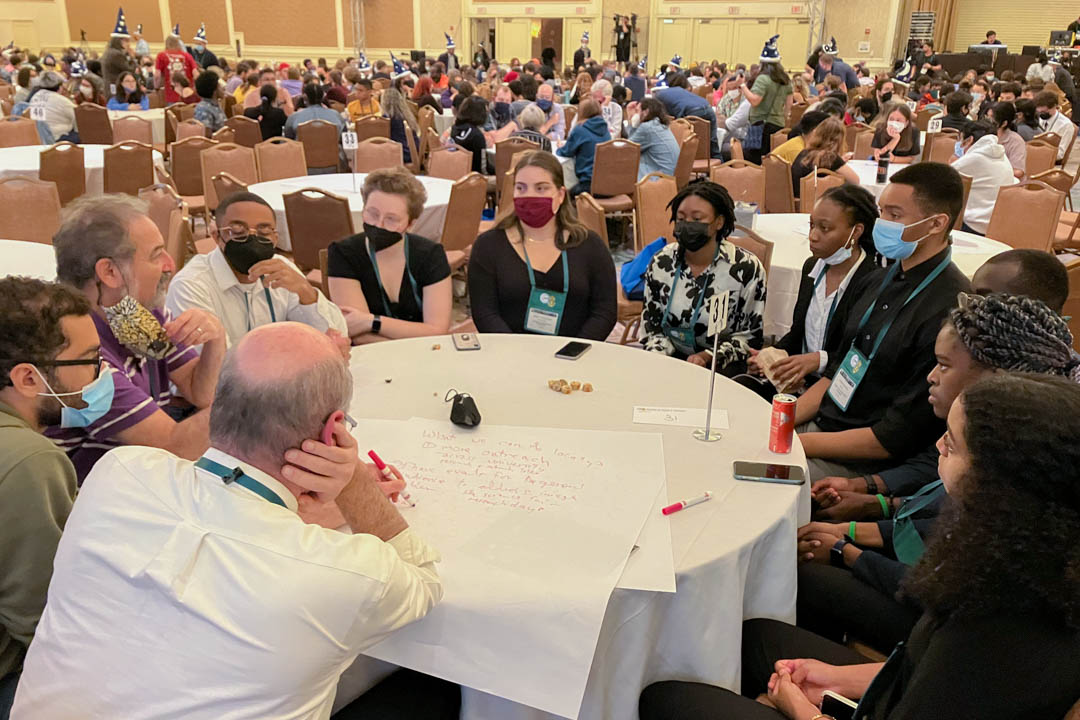 Large room of people at tables attending the Physics Congress 2022