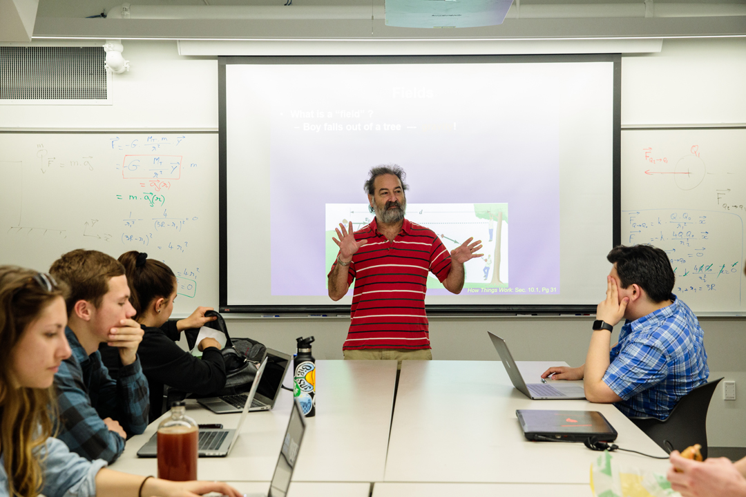 Physics professor Alex Feldman lecturing a small group of students